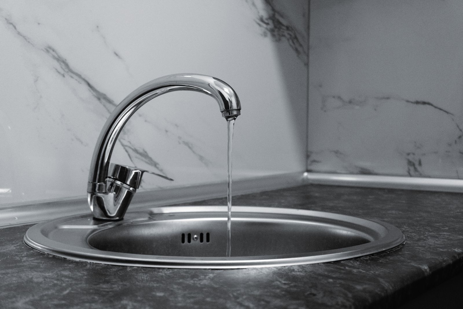 Chrome kitchen faucet with running water