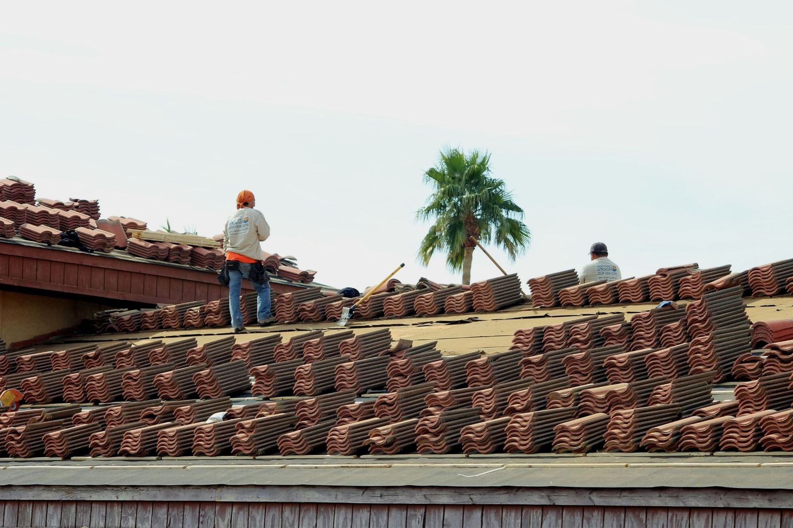 Workers installing terra cotta roof tiles